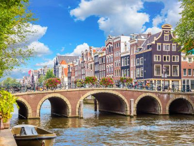 Amsterdam downtown - Amstel river, old houses and a bridge. Nice view of the famous city of Amsterdam. Travel to Europe. Amsterdam, Holland, Netherlands, Europe.