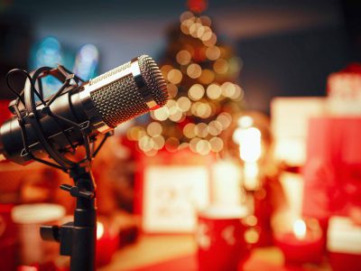 Christmas decorations, gifts and professional microphone in the foreground: holiday podcast concept